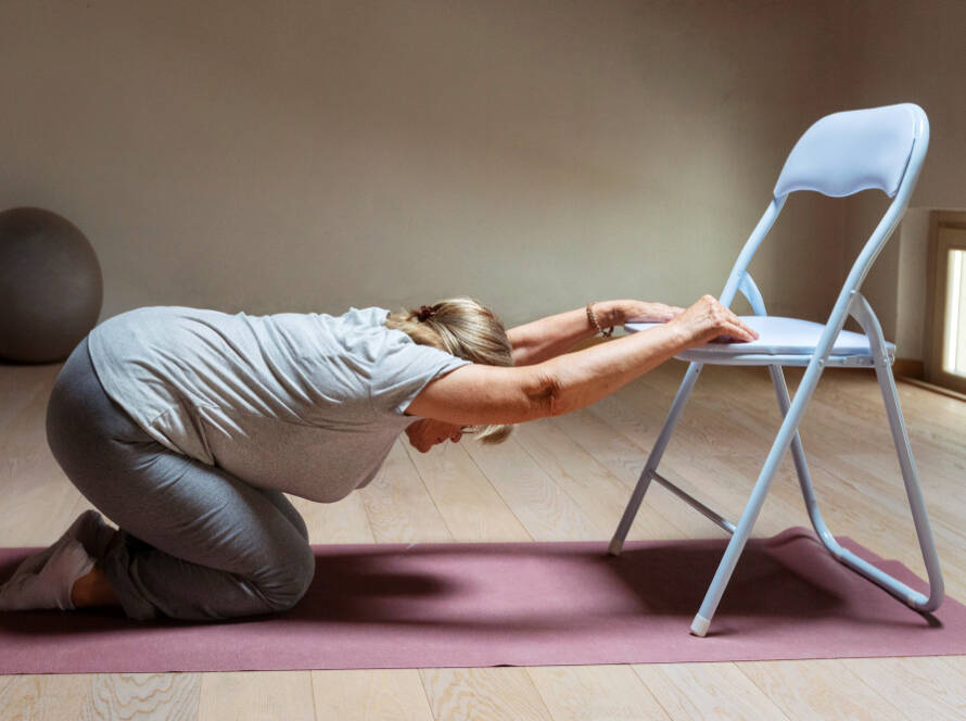 Mujer haciendo yoga con silla